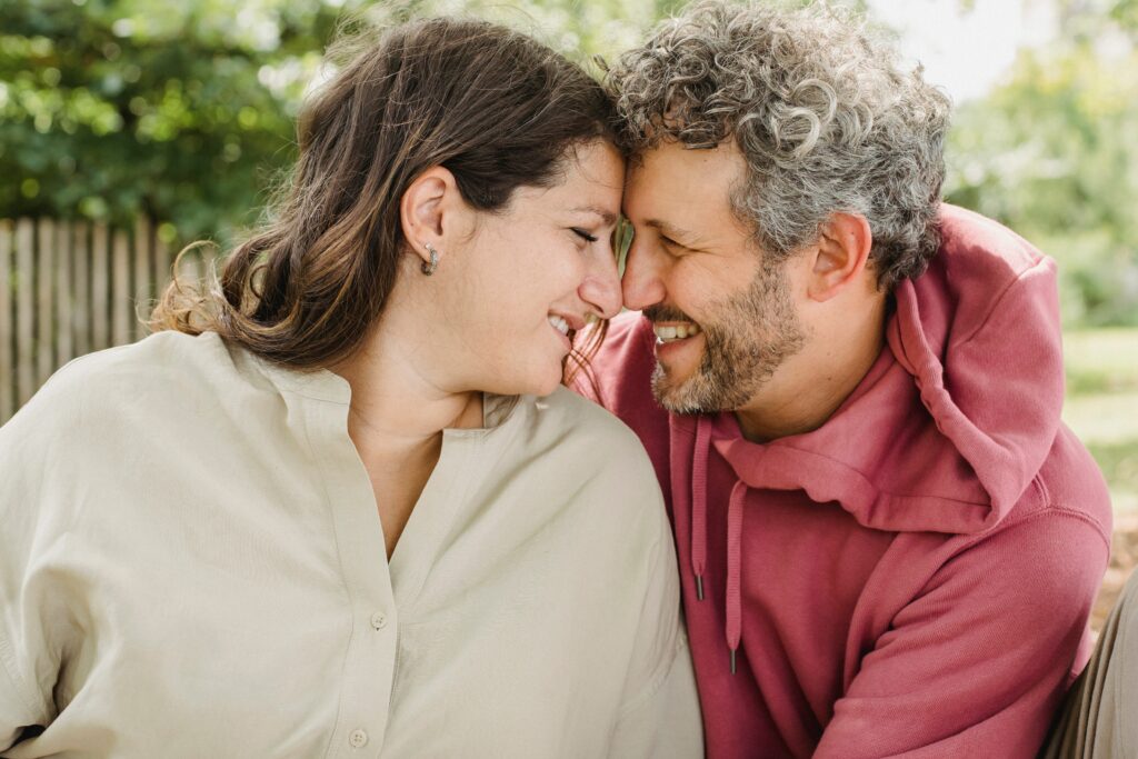 Homme et femme de 40 ans souriants attablés en terrasse à Paris